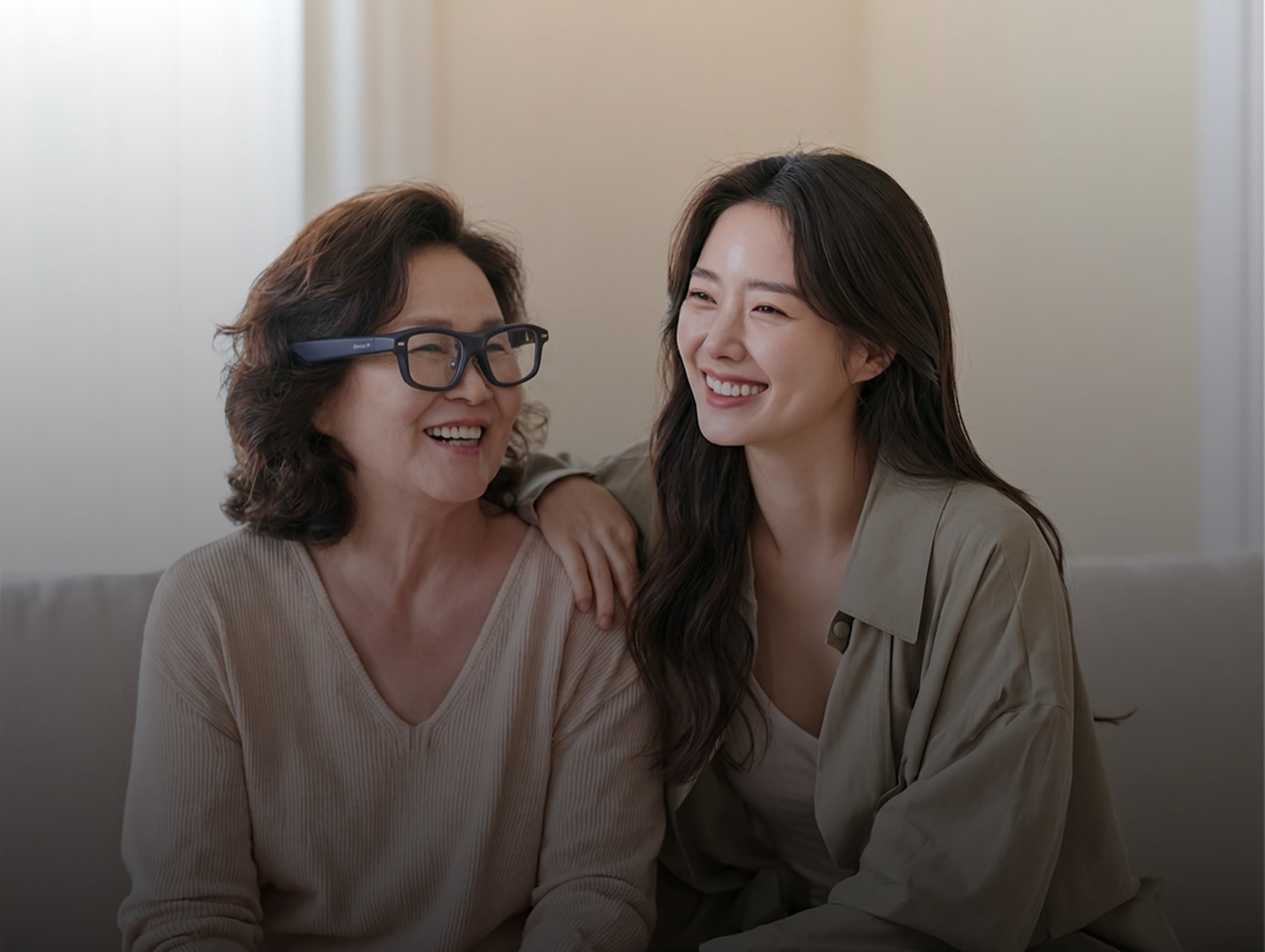 Two women smiling together, one wearing C-Sound AI subtitle glasses